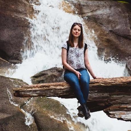 Me, sitting on a tree branch in front of a waterfall